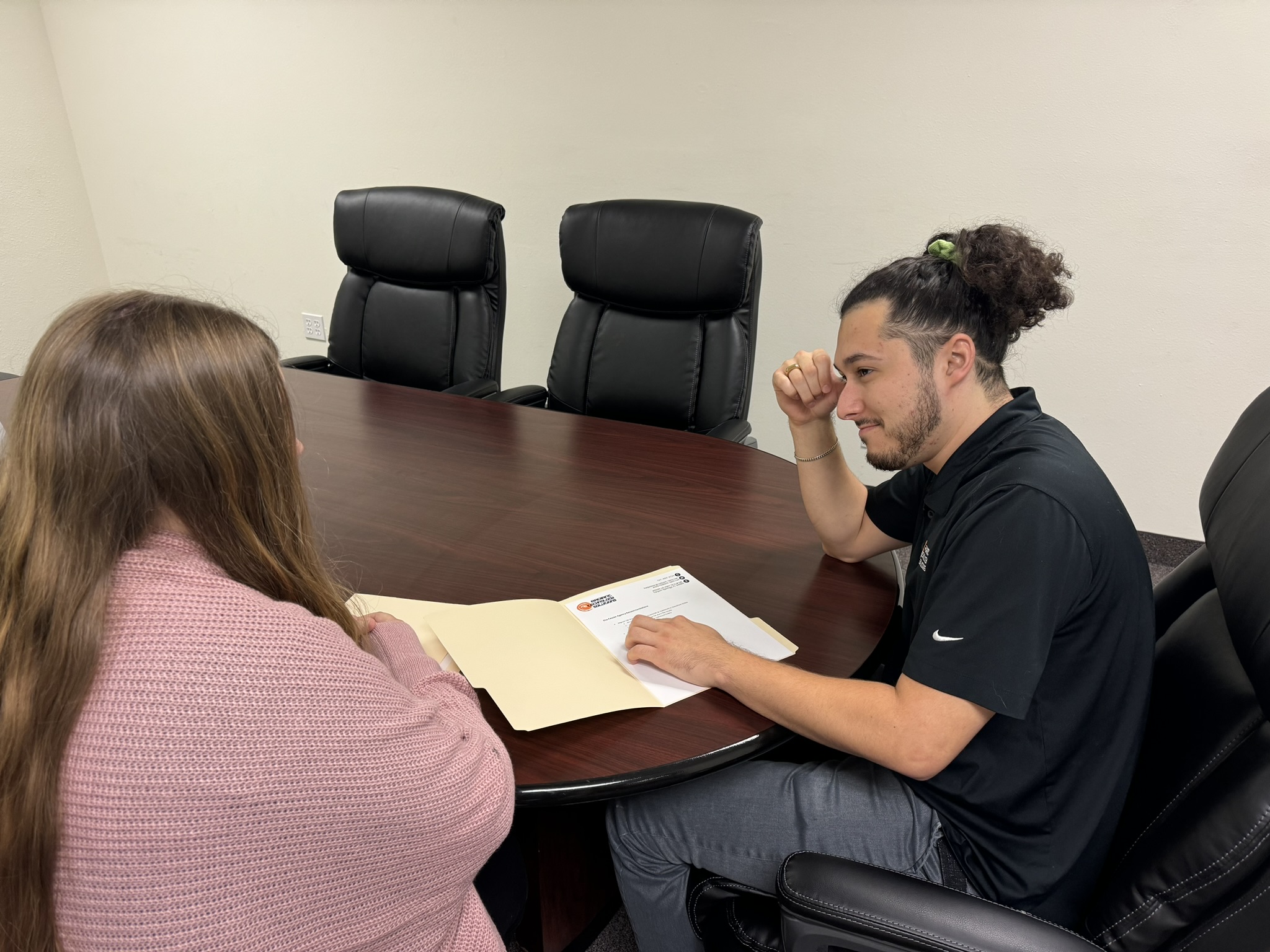 IT support professional consulting with a client at a conference table during a business meeting
