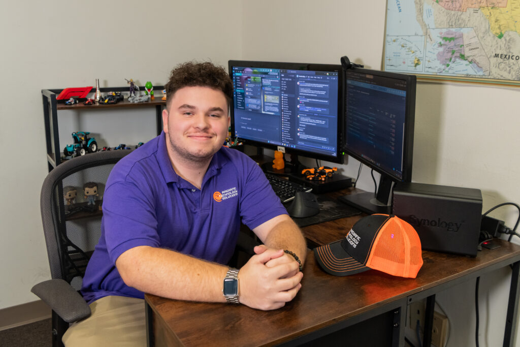 IT support team member working at a dual-monitor workstation displaying Microsoft Teams collaboration tools and managed services dashboards.